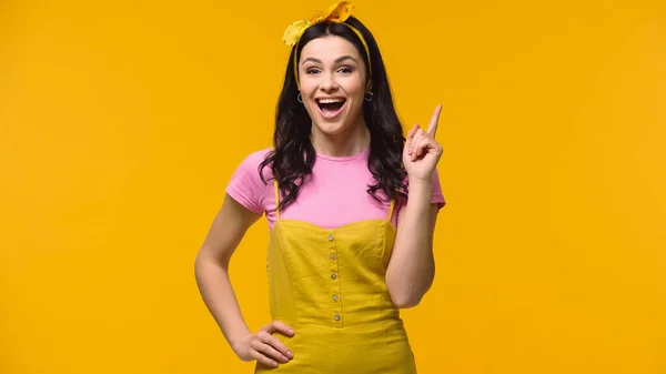 Mujer emocionada teniendo idea mientras mira la cámara aislada en amarillo - foto de stock