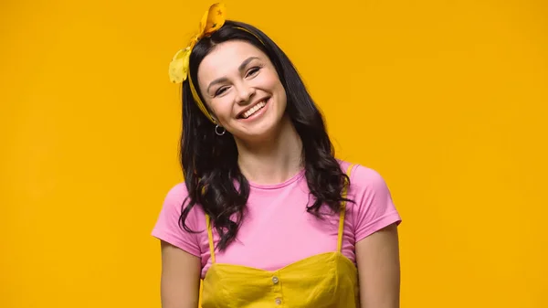 Happy young woman smiling at camera isolated on yellow — Stock Photo