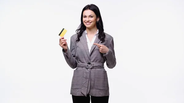 Mujer de negocios sonriente apuntando a la tarjeta de crédito aislada en blanco - foto de stock