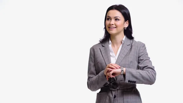 Mujer de negocios sonriente tocando reloj de pulsera aislado en blanco - foto de stock