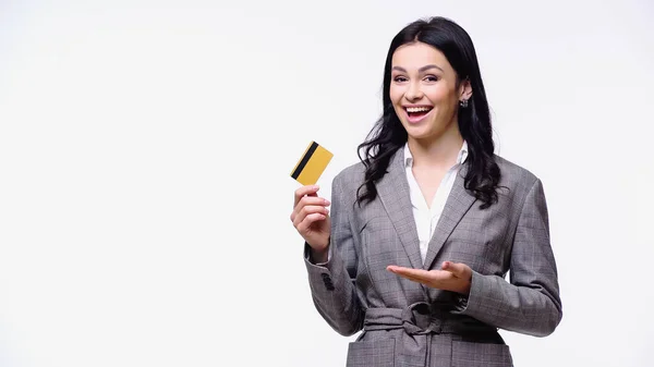 Positive businesswoman pointing at credit card isolated on white — Stock Photo