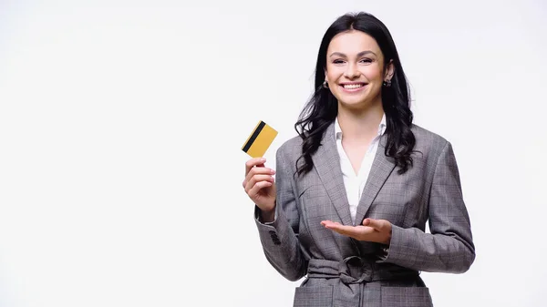 Happy businesswoman pointing at credit card isolated on white — Stock Photo