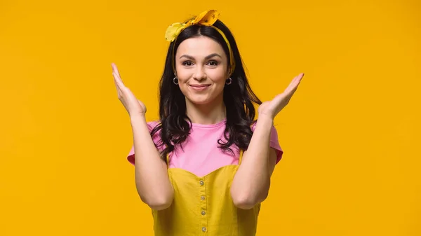 Smiling woman in headband and t-shirt looking at camera isolated on yellow — Stock Photo
