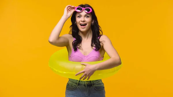 Astonished woman in sunglasses and swim ring isolated on yellow — Stock Photo