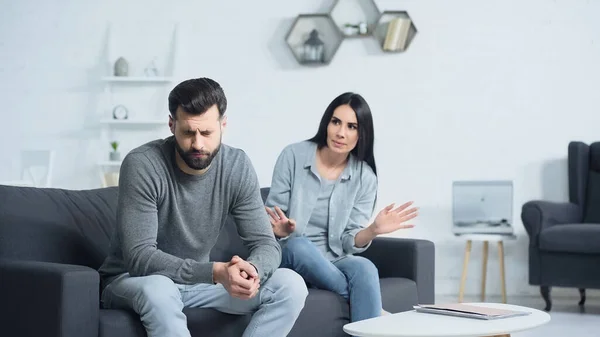 Unzufriedene Frau streitet mit frustriertem Mann im Wohnzimmer — Stockfoto