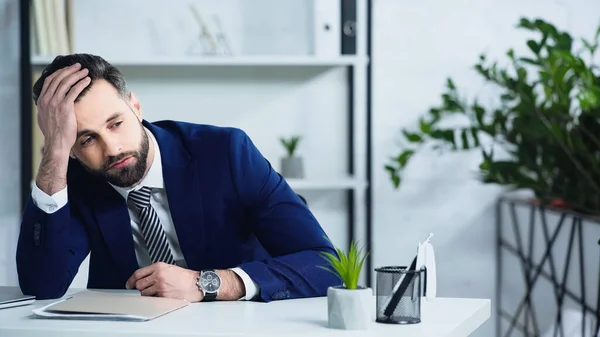 Trauriger Geschäftsmann im Anzug sitzt im Büro — Stockfoto