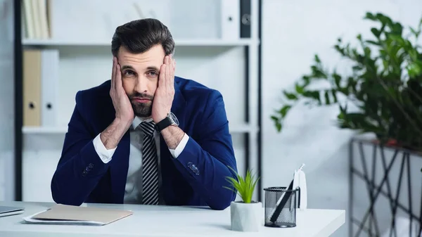 Homem de negócios cansado em terno sentado no escritório — Fotografia de Stock