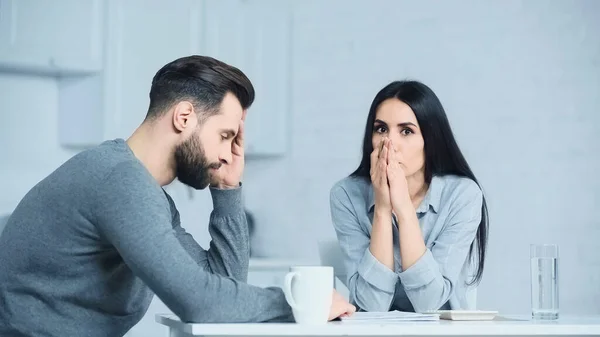 Traurige Frau blickt in Kamera und verärgert Mann zu Hause — Stockfoto