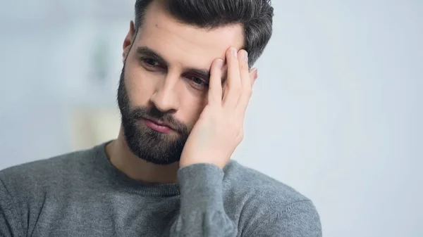 Stressed and bearded man touching face at home — Stock Photo