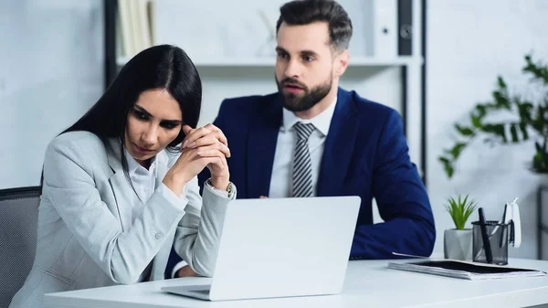 Turbato donna d'affari guardando lontano vicino sfocato uomo d'affari litigando in ufficio — Foto stock