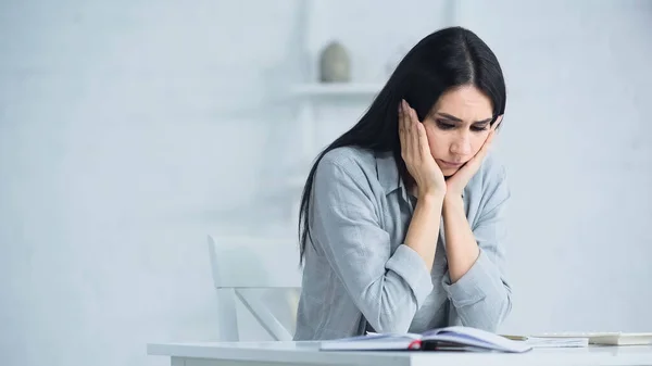 Стресова жінка сидить біля калькулятора на столі — стокове фото