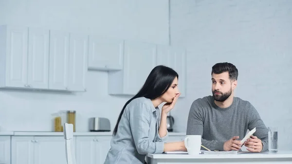 Bärtiger Mann zeigt Frau Taschenrechner — Stockfoto