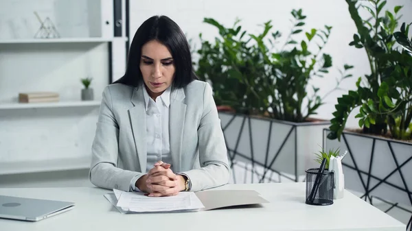 Unzufriedene Geschäftsfrau atmet auf und schaut sich Unterlagen im Büro an — Stockfoto