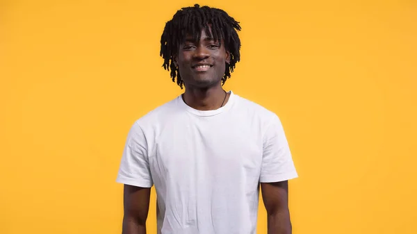 Smiling happy african american man with dreadlocks isolated on yellow — Stock Photo