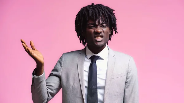 Skeptical african american businessman pointing with hand isolated on pink — Stock Photo