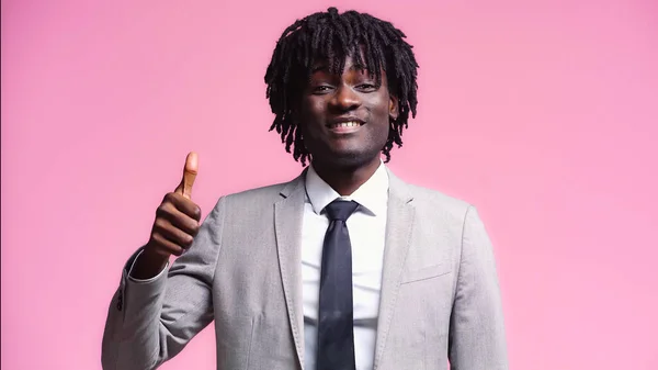 Cheerful african american businessman showing thumb up isolated on pink — Stock Photo