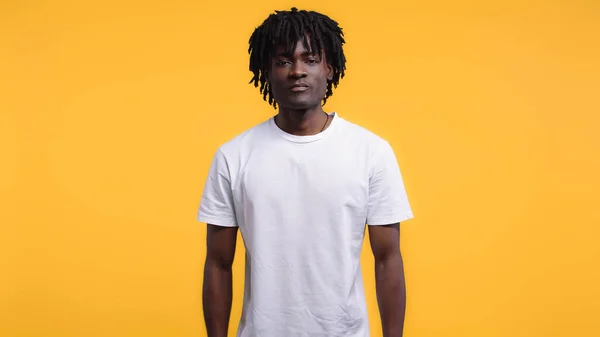 Young african american man in white t-shirt isolated on yellow — Stock Photo