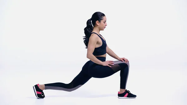 Flexible young sportswoman stretching on white — Stock Photo