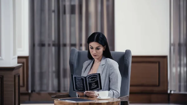 Businesswoman looking at menu in lobby of restaurant — Foto stock