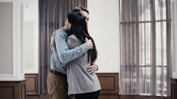 Business colleagues hugging in restaurant lobby — Photo de stock