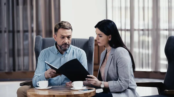 Geschäftskollegen arbeiten in Restaurant-Lobby mit Dokumenten — Stockfoto