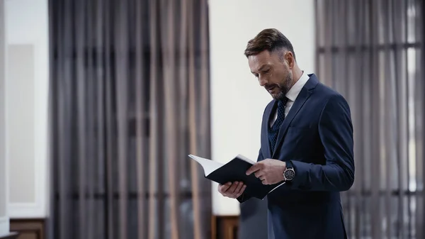 Businessman looking at documents in paper folder — Photo de stock