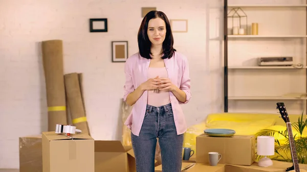 Cheerful woman looking at camera in new home — Stock Photo