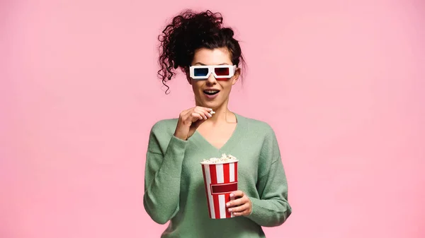 Überraschte Frau in 3D-Gläsern mit Popcorn auf rosa — Stockfoto