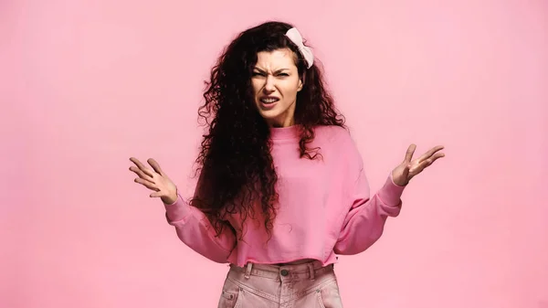 Mulher indignada olhando para a câmera e gesticulando isolado em rosa — Fotografia de Stock