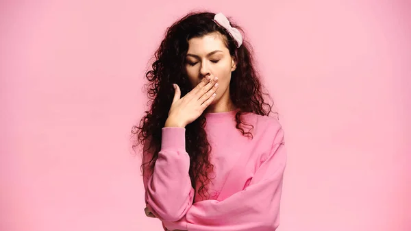 Schläfrige Frau bedeckt Mund mit der Hand, während Gähnen isoliert auf rosa — Stockfoto