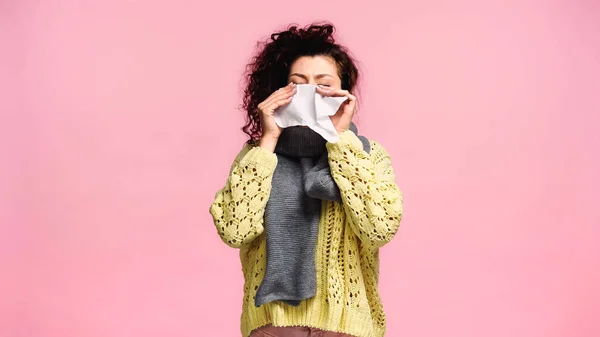 Donna malata starnuti in tovagliolo di carta con gli occhi chiusi isolati su rosa — Foto stock