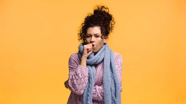 Mujer enferma en suéter de punto y bufanda tos aislada en naranja - foto de stock