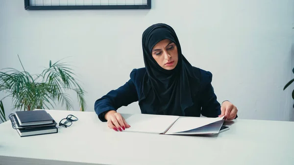 Mulher de negócios muçulmana trabalhando com papéis no escritório — Fotografia de Stock