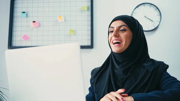 Heureux musulman femme d'affaires ayant appel vidéo sur ordinateur portable dans le bureau — Photo de stock
