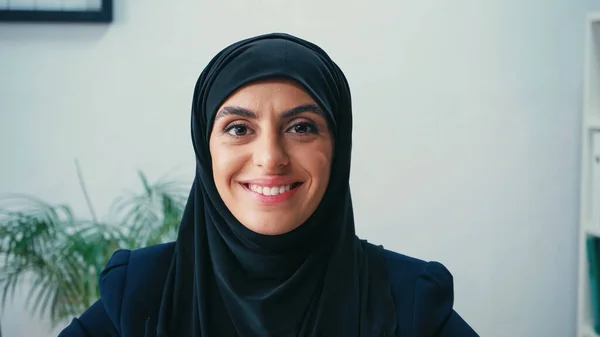 Mulher de negócios árabe alegre no hijab olhando para a câmera — Fotografia de Stock