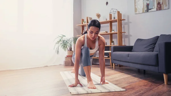 Sportswoman che lavora sul tappetino fitness a casa — Foto stock