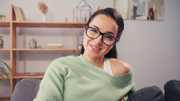 Positive Frau mit Brille blickt zu Hause in die Kamera — Stockfoto