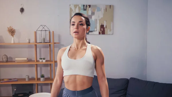 Athletic sportswoman standing in living room — Stock Photo