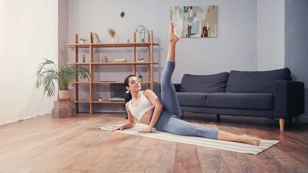 Athlétisme sportif entraînement sur tapis de fitness dans le salon — Photo de stock