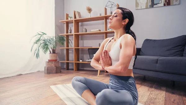 Seitenansicht einer hübschen Frau, die zu Hause Yoga praktiziert — Stockfoto