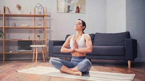 Deportista descalza practicando yoga en salón - foto de stock