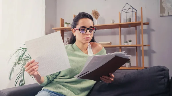 Student holding papers and folder at home — Stock Photo