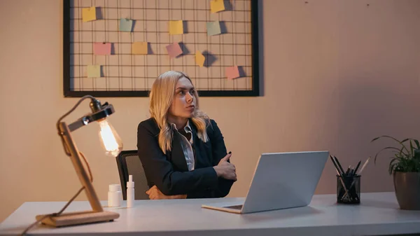 Femme d'affaires assis près de pulvérisation nasale et des pilules sur la table de travail au bureau — Photo de stock