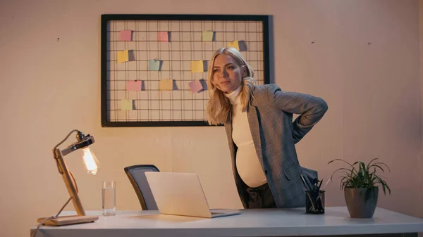 Schwangere Geschäftsfrau leidet unter Rückenschmerzen im Büro — Stockfoto