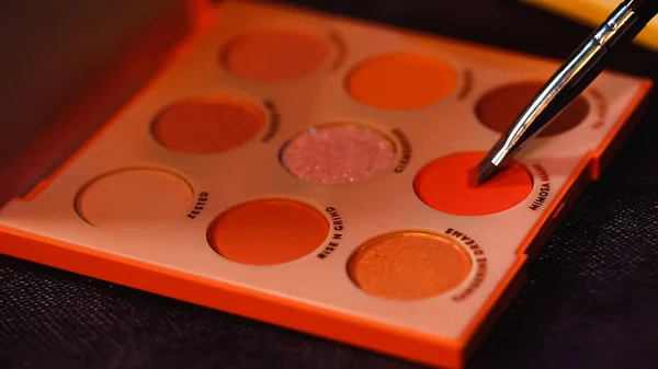Cosmetic brush near palette with colorful eye shadow — Stock Photo