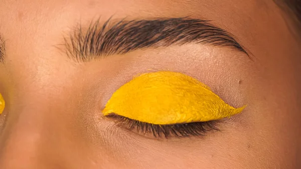 Частичный взгляд женщины с желтой сливочной тенью для глаз — Stock Photo