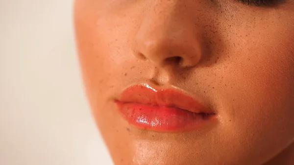 Vista ritagliata di donna con labbra lucide isolate su bianco — Foto stock