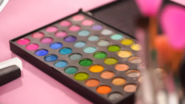 Set of eye shadow palette with different colors on pink — Stock Photo