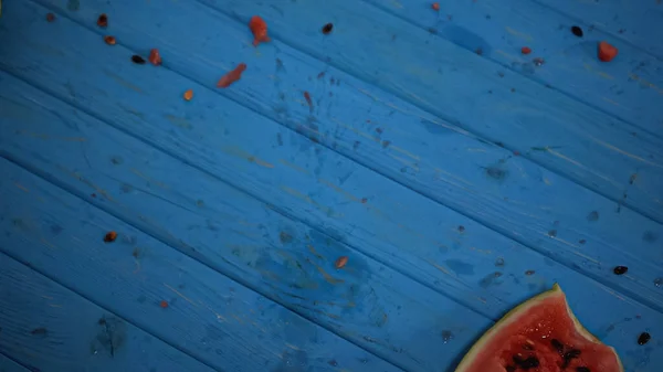 Top view of crushed watermelon near seeds on blue surface — Stock Photo