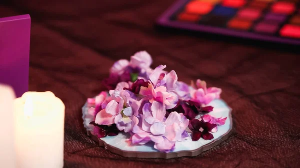 Close up of blooming flowers near burning candle — Stock Photo